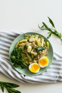 Rice With Zucchini, Soft Boiled Egg, and Parsley in Green Ceramic Plate